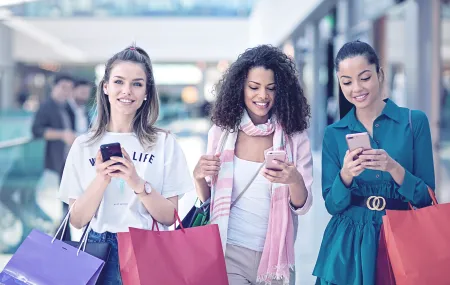 Retail_Girls shopping in a mall_Looking smartphone.png