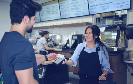 Coffee shop_Payment at counter_AXIUM DX80000_Lady holding the terminal_Contactless payment.png