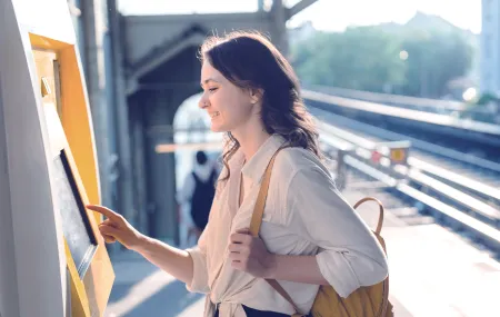 Woman using kiosk to purchase train ticket