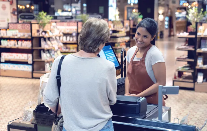 Retail_Woman checkout supermarket_Cashier smiling.png