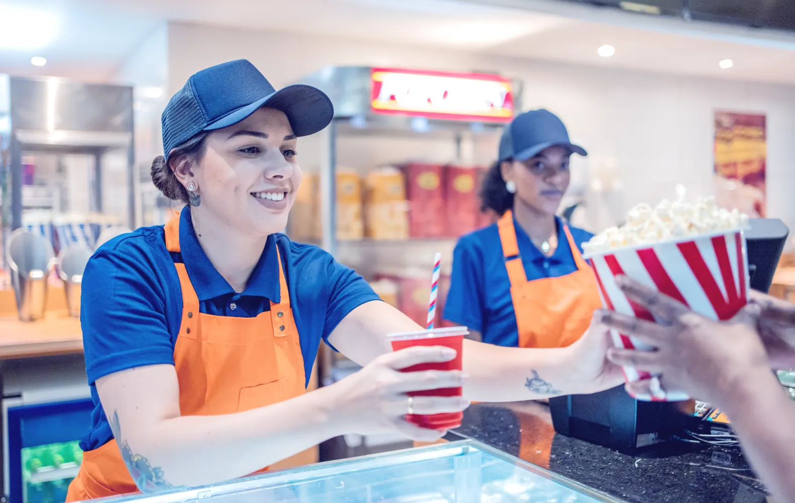 Women giving popcorn to a customer.png